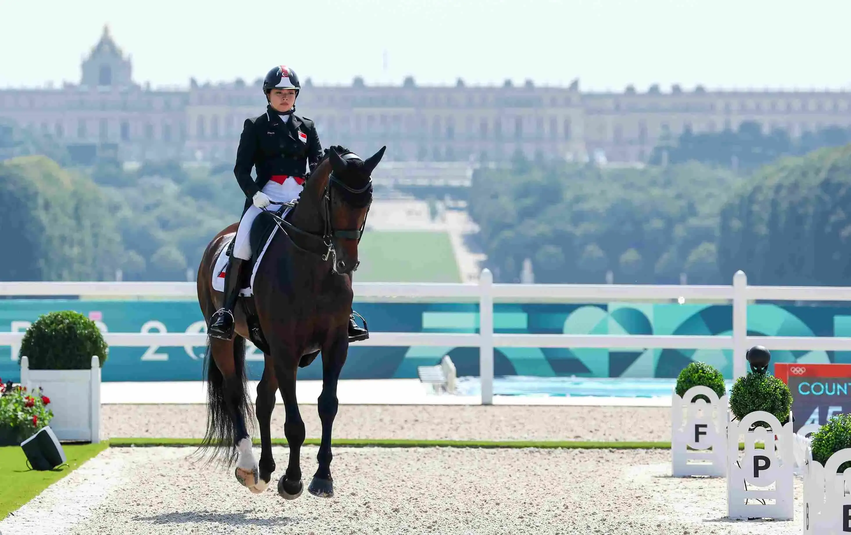Caroline Chew rides her horse Zatchmo during their individual dressage grand prix performance at the 2024 Paris Games with Château de Versailles in the background.  Photo: Sport Singapore/Jeremy Lee