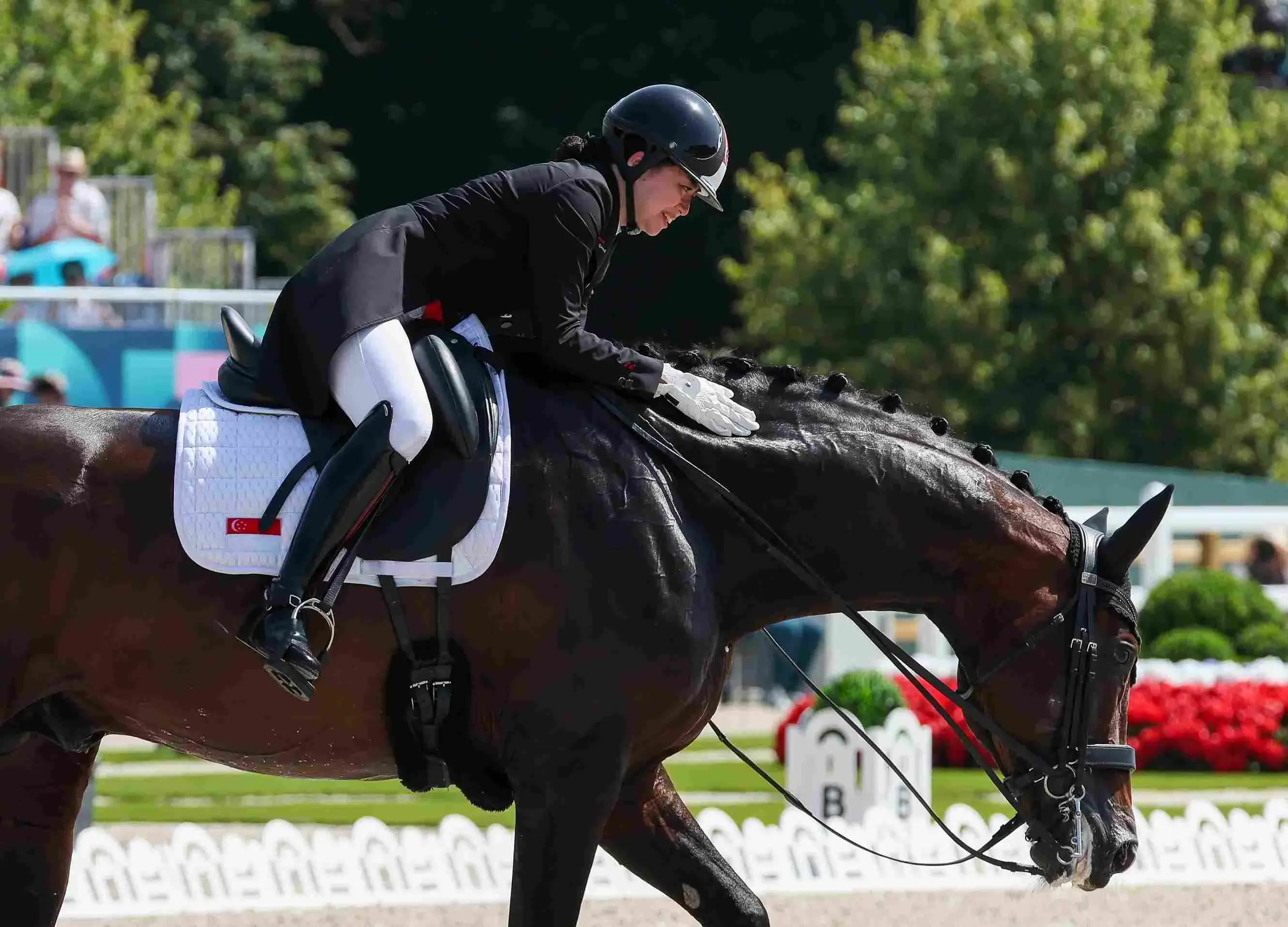 Caroline Chew gives her horse Zatchmo a congratulatory pat after they complete their individual dressage grand prix performance at the 2024 Paris Games.  Photo: Sport Singapore/Jeremy Lee